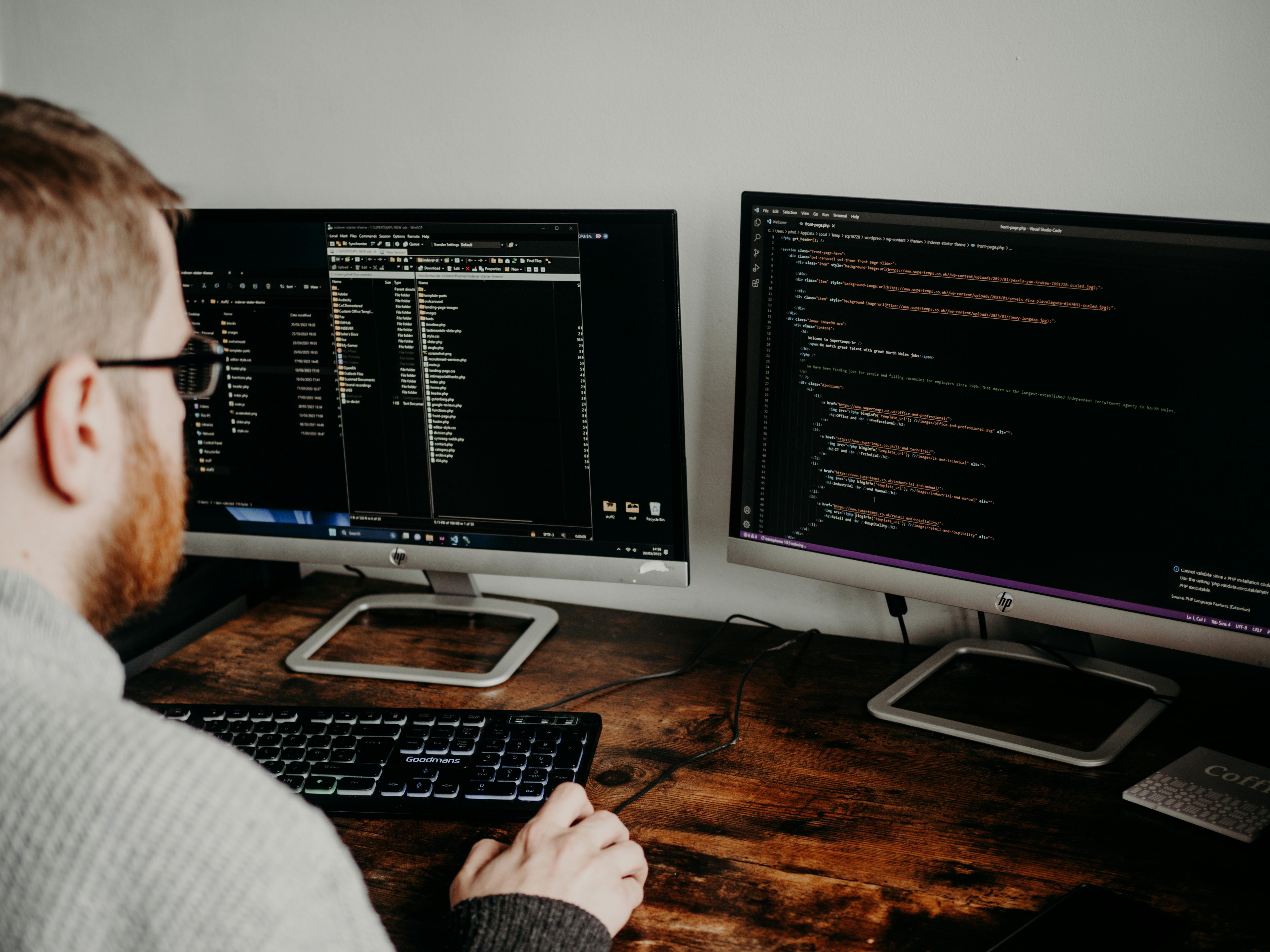Developer workspace with code on screens